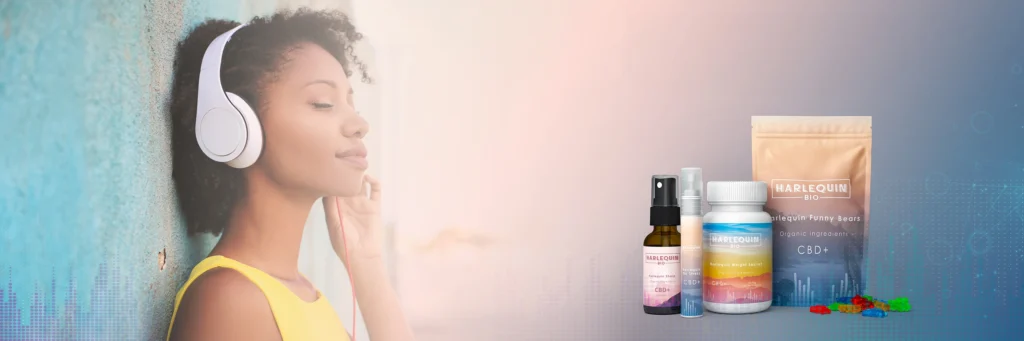 Lifestyle banner featuring 3D package rendering of Harlequin Bio CBD oils, gummies, and sprays alongside a woman wearing headphones.